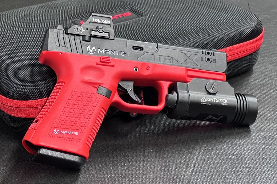 An orange and black training pistol leaning up against a case.