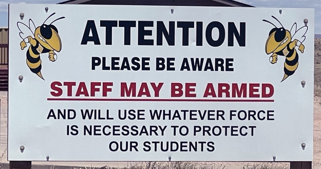 school staff armed sign feat